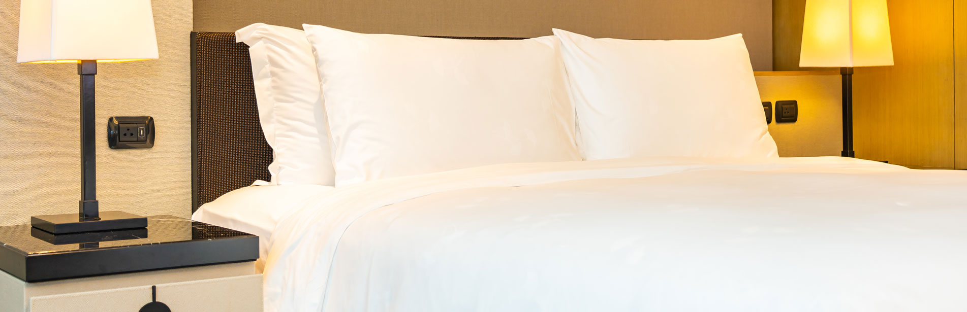 White comfortable pillow and blanket on bed